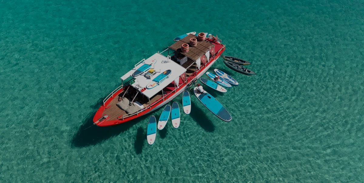 Drone view of Salvador Ibiza in Cala Comte showing turquoise water and paddleboard shadows