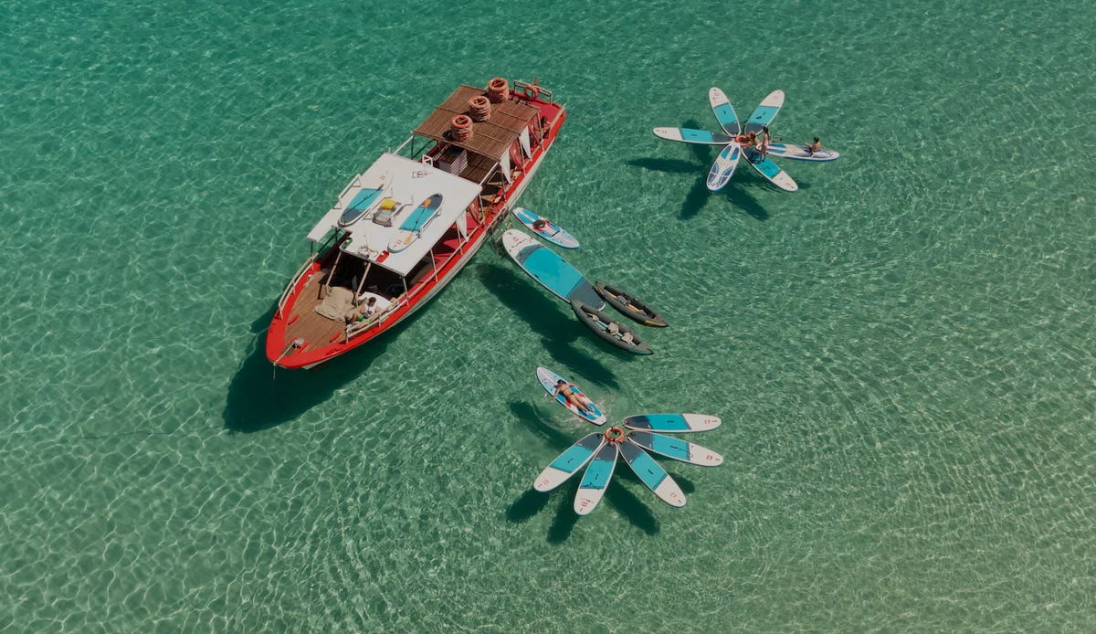 Aerial view of Salvador Ibiza in Cala Comte with paddleboards in crystal-clear turquoise water